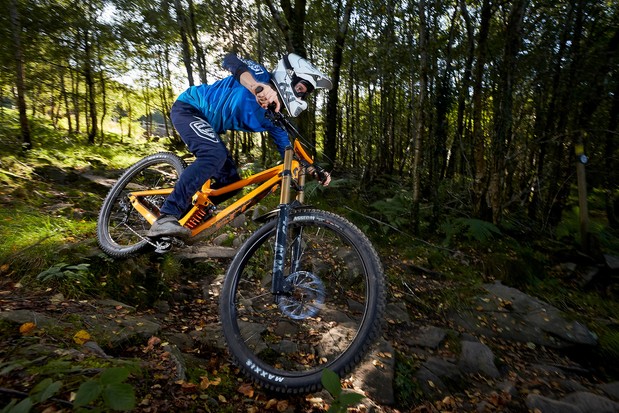 Cycliste masculin équitation vélo de montagne à suspension complète orange dans les bois