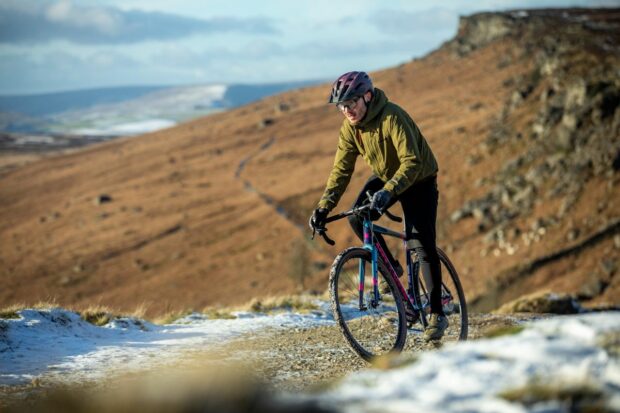 A rider on a Planet X gravel bike rides along a snowy path