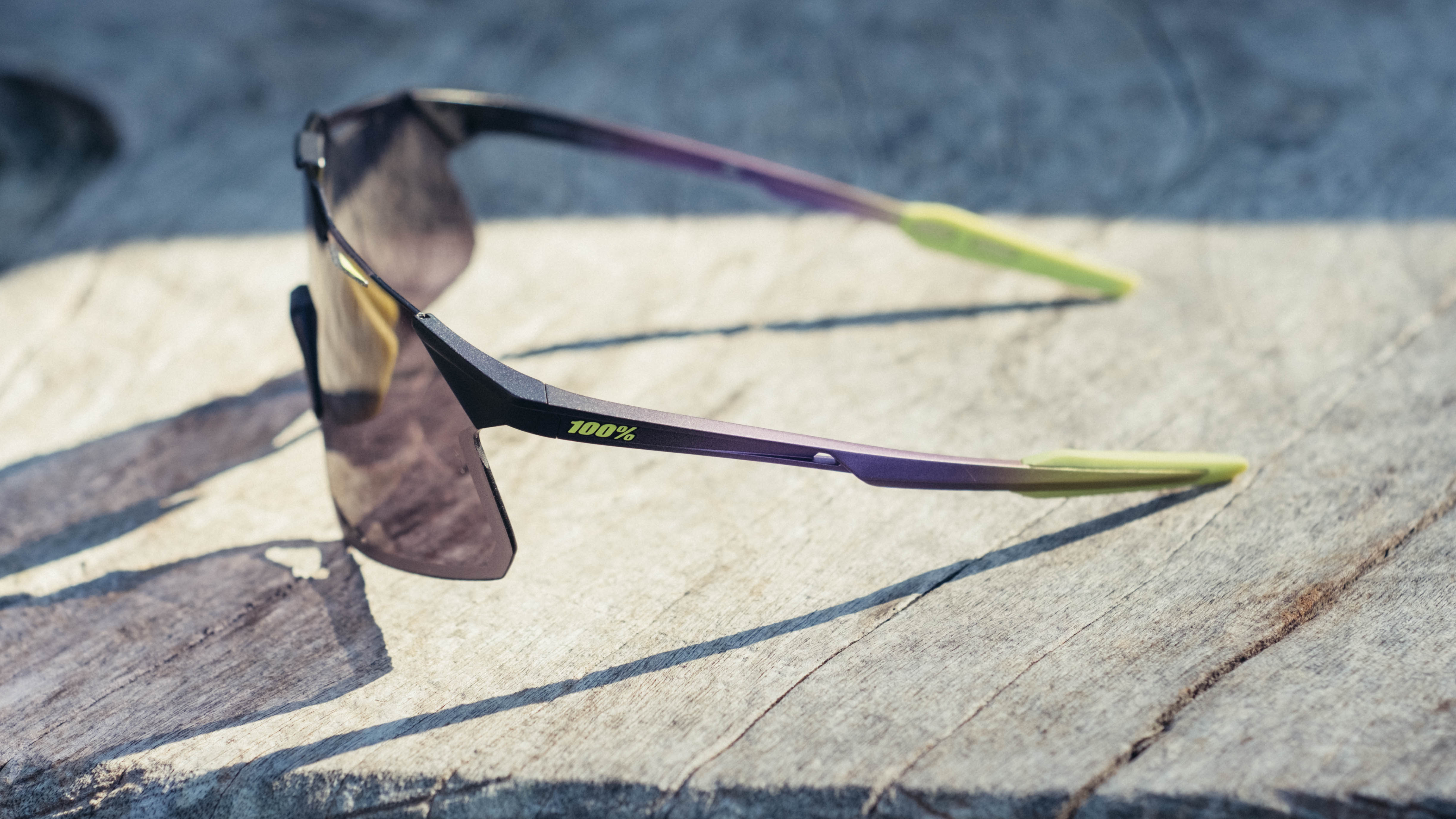 Une paire de lunettes de vélo 100% Hypercraft sur un banc en bois