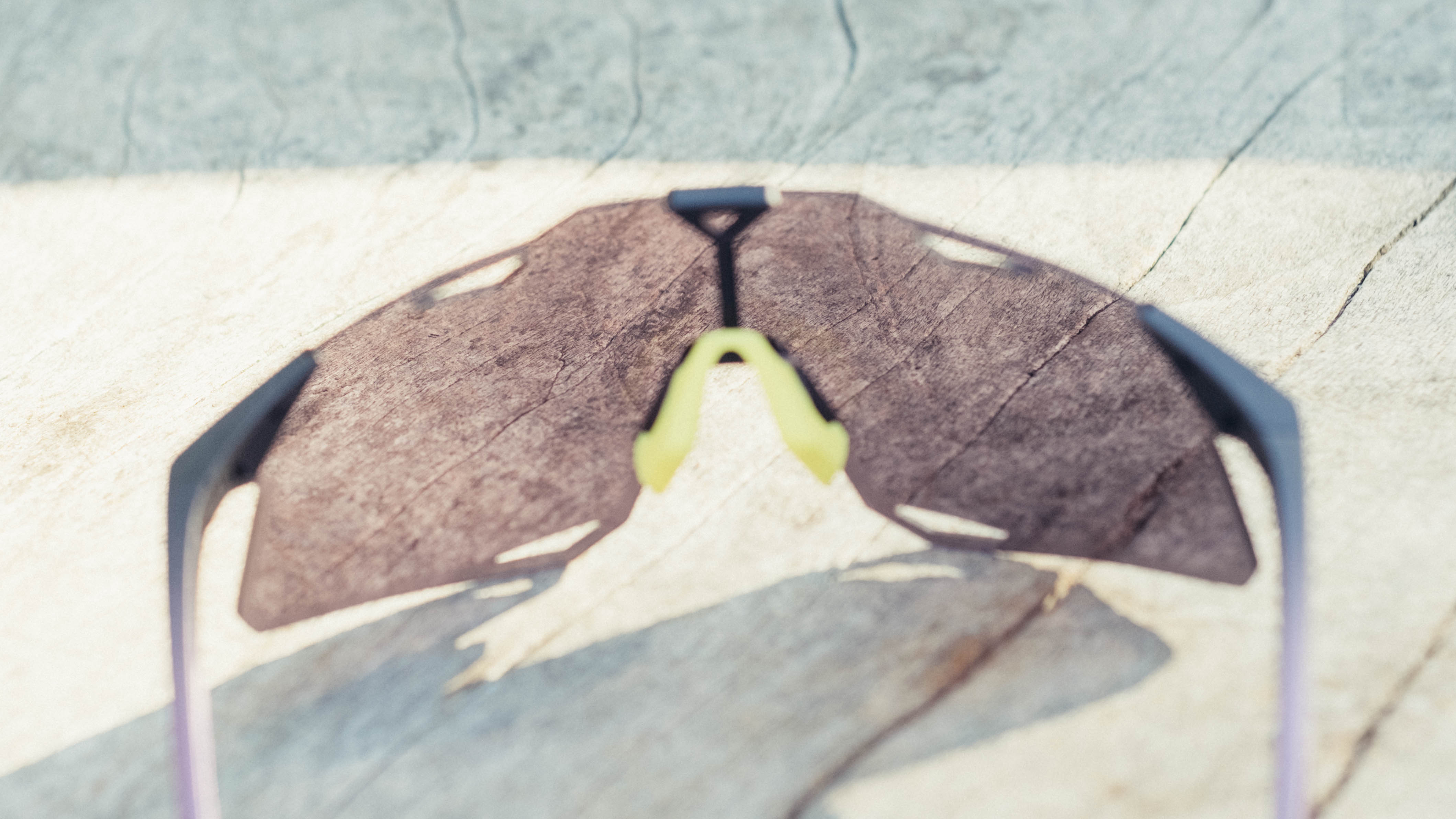 Une paire de lunettes de vélo 100% Hypercraft sur un banc en bois
