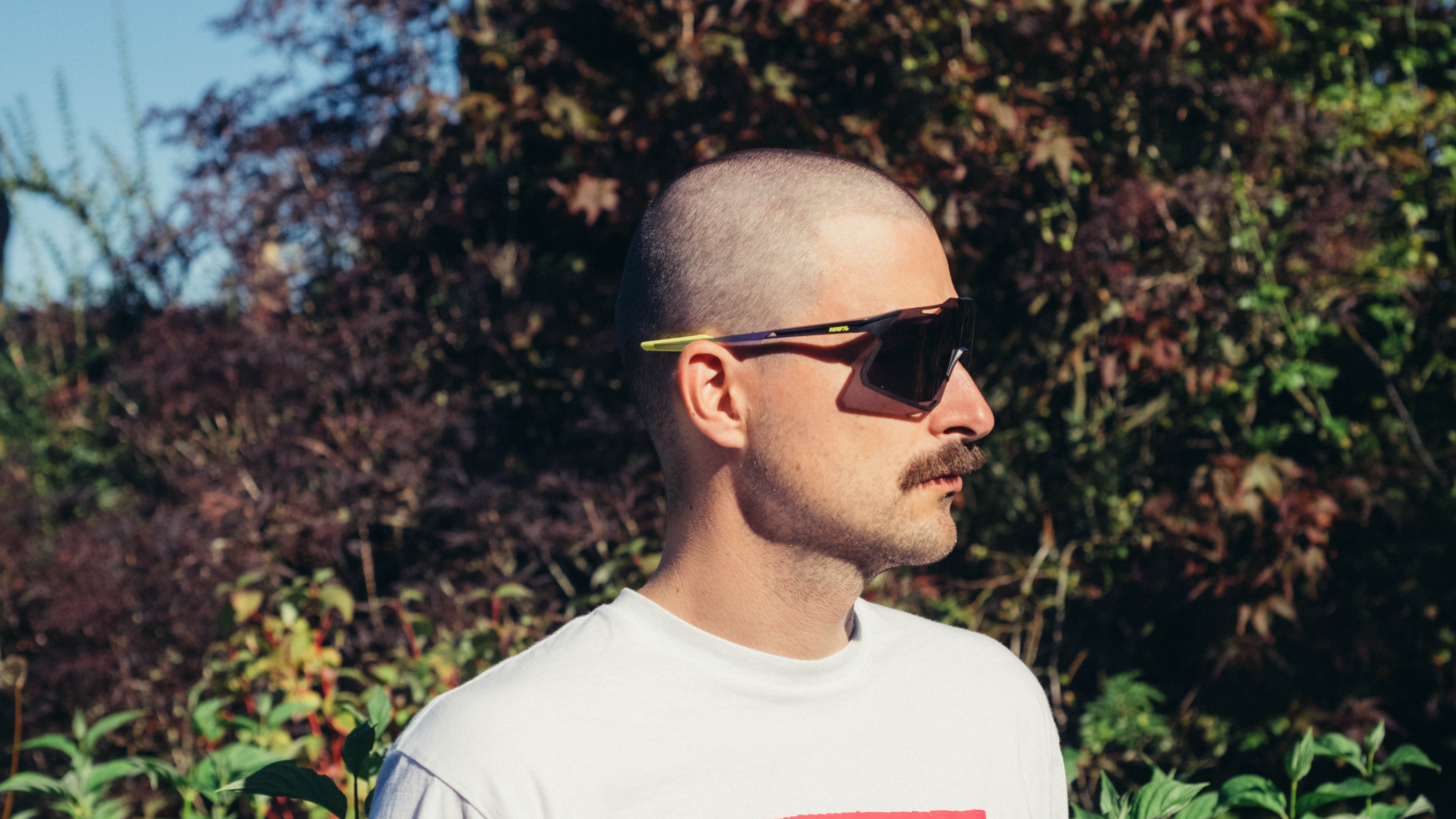 Un homme blanc à moustache porte une paire de lunettes de vélo 100% Hypercraft