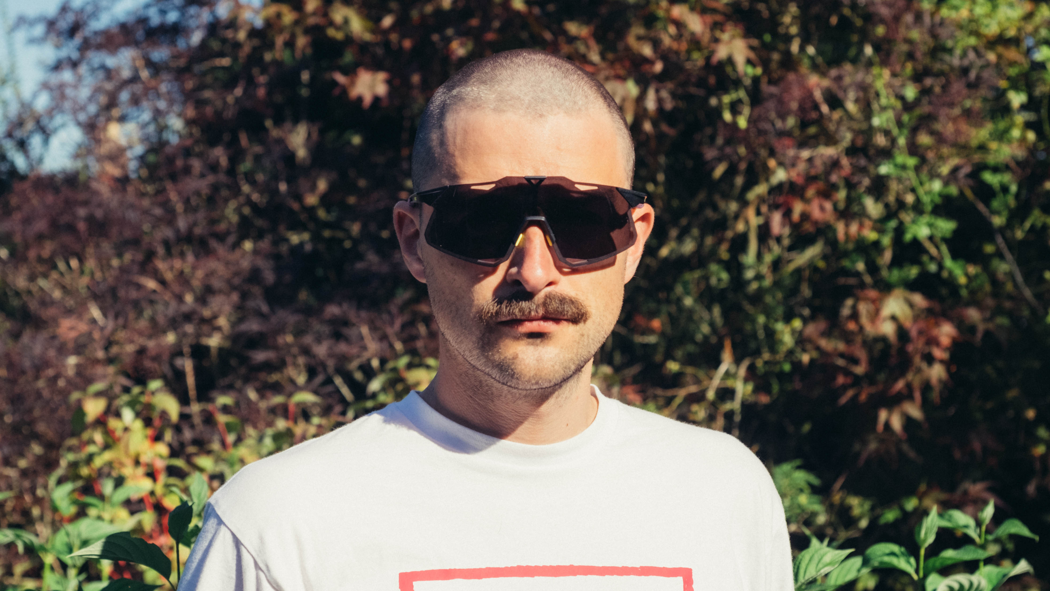 Un homme blanc à moustache porte une paire de lunettes de vélo 100% Hypercraft