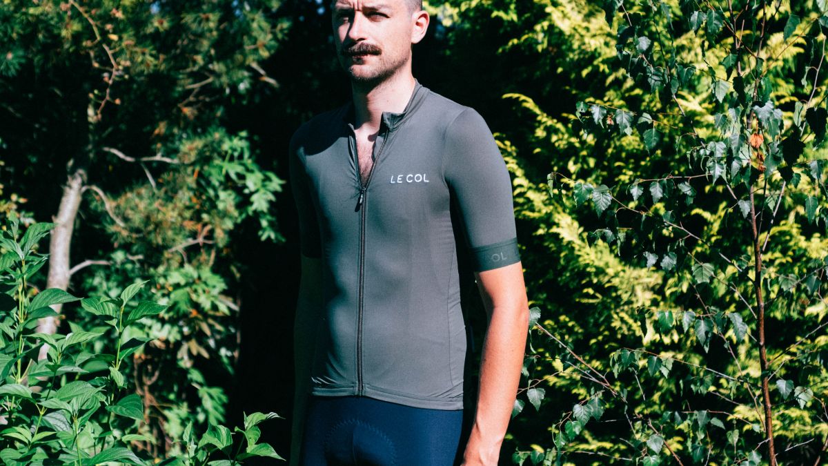 A white man with a moustache wears the sage green le col pro jersey II