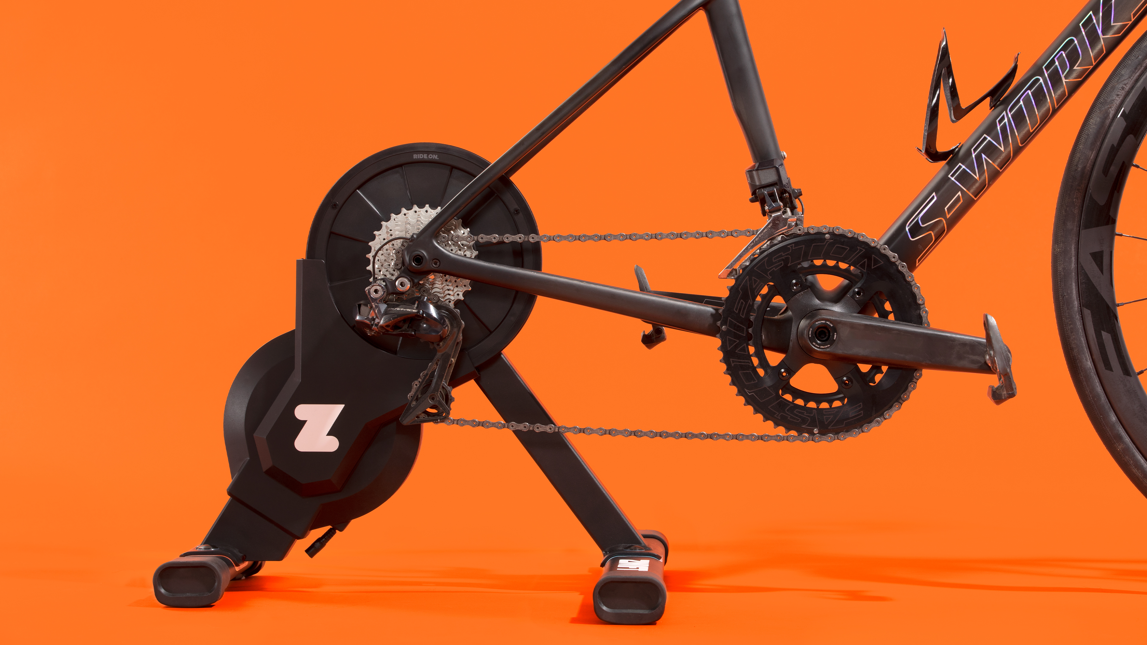 Un Zwift Hub monté sur un vélo sur fond orange