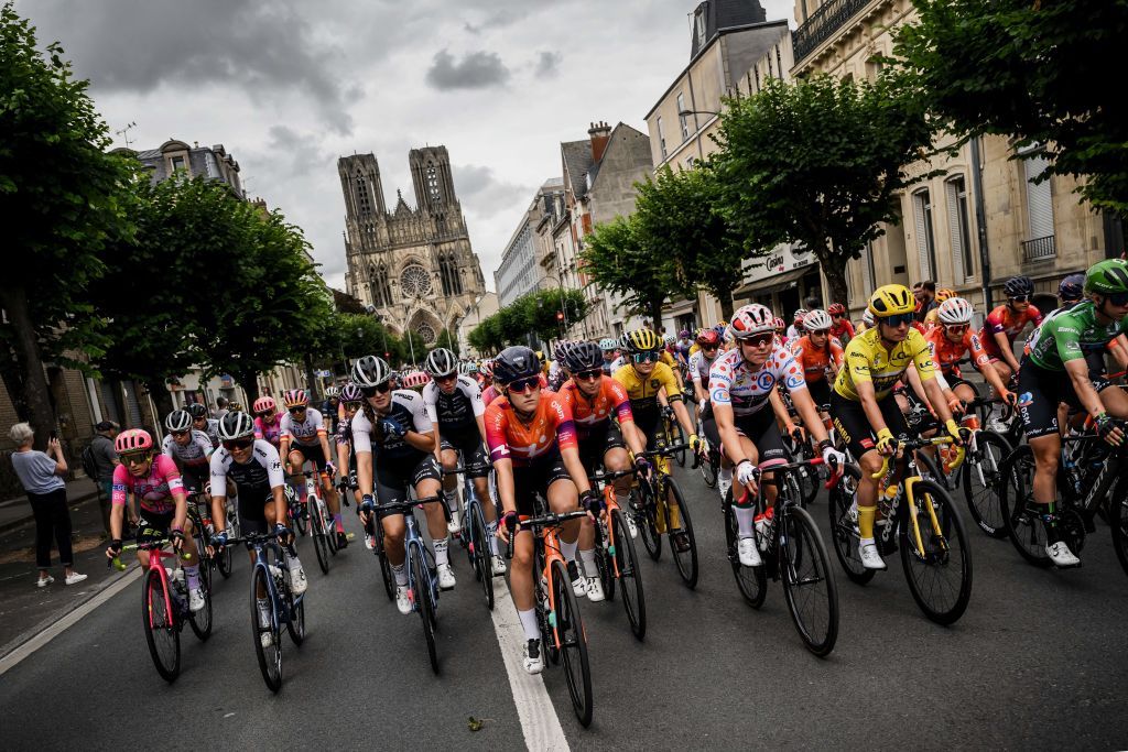 TOPSHOT The pack rides away from Reims Cathedral during the 3rd stage of the new edition of the Womens Tour de France cycling race 1336 km between Reims and Epernay on July 26 2022 Photo by JEFF PACHOUD AFP Photo by JEFF PACHOUDAFP via Getty Images