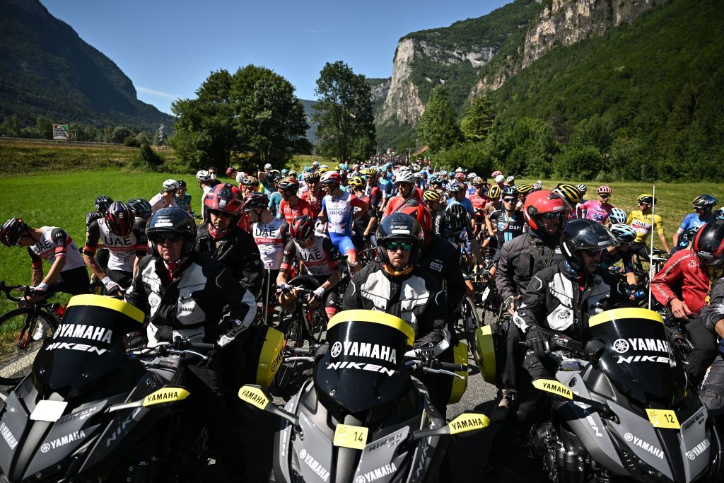 TOPSHOT The pack of riders is temporarily immobilized by race regulators front due to protest action on the race route during the 10th stage of the 109th edition of the Tour de France cycling race 1481 km between Morzine and Megeve in the French Alps on July 12 2022 Photo by Marco BERTORELLO AFP Photo by MARCO BERTORELLOAFP via Getty Images