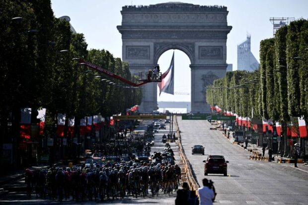 TOPSHOT The pack rides on the Champs Elysee avenue with the Arc de Triomphe in the background during the 21th and last stage of the 108th edition of the Tour de France cycling race 108 km between Chatou and Paris ChampsElysees on July 18 2021 Photo by AnneChristine POUJOULAT AFP Photo by ANNECHRISTINE POUJOULATAFP via Getty Images