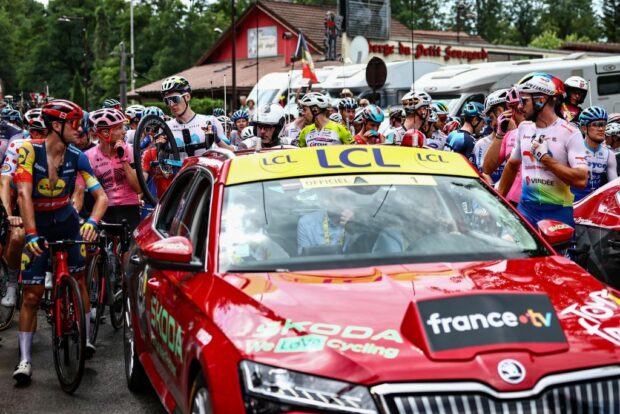 Riders await the stage 14 restart at the Tour de France after the race was neutralised following a mass crash