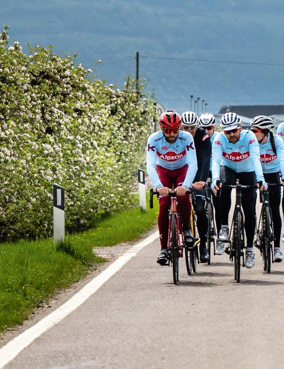 groupe de cyclistes sur route descendant une colline
