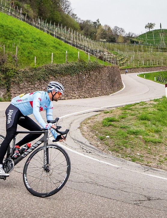 Cycliste masculin équitation vélo de route noir en bas de la colline sur le virage