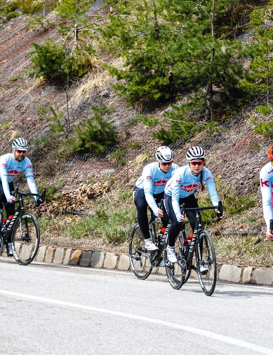 groupe de cyclistes sur route descendant une colline
