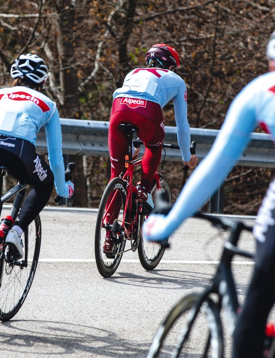 groupe de cyclistes sur route descendant une colline