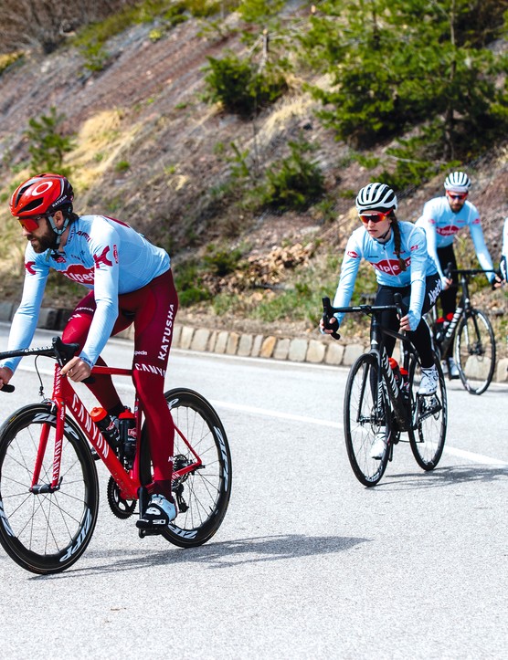 groupe de cyclistes sur route descendant une colline