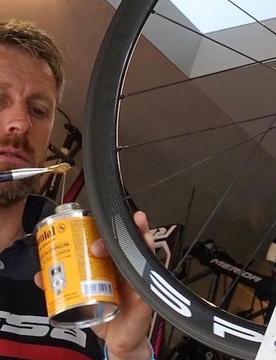 Moreno utilise un pinceau étroit pour appliquer une fine couche de colle sur la jante