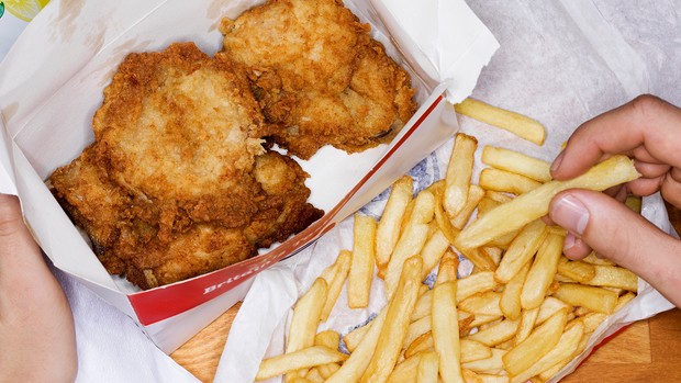 Hommes mangeant de la restauration rapide, du poulet frit et des frites