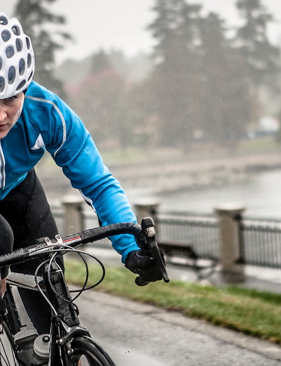 Une femme s'entraîne sur son vélo sous la pluie