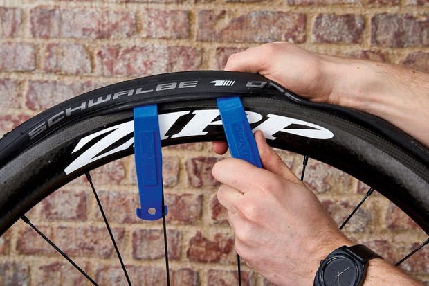 Utilisez un démonte-pneu – ou deux, si nécessaire – pour soulever un côté du pneu de la jante.