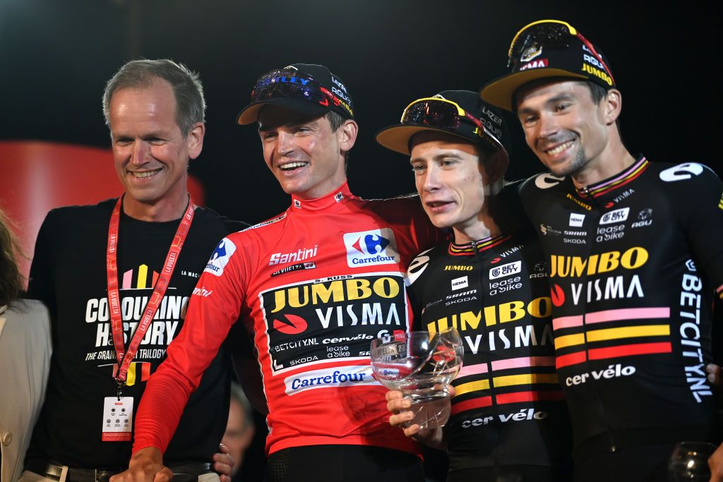 Jumbo-Visma manager Richard Plugge on the Vuelta a España podium with Sepp Kuss, Jonas Vingegaard, and Primož Roglič