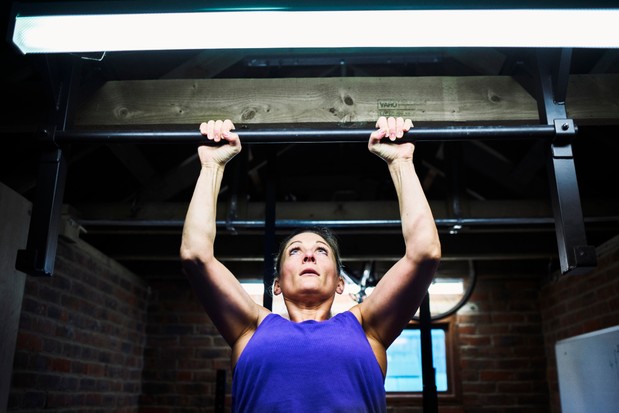 Femme exerçant dans une salle de sport sur mesure, dans un petit garage reconverti à la maison, spécialement aménagé pour les exercices de gymnastique.
