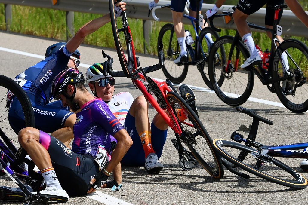 Alan Jousseaume (TotalEnergies) in the centre of shot on the ground after his stage 12 crash at the Vuelta a España 2023