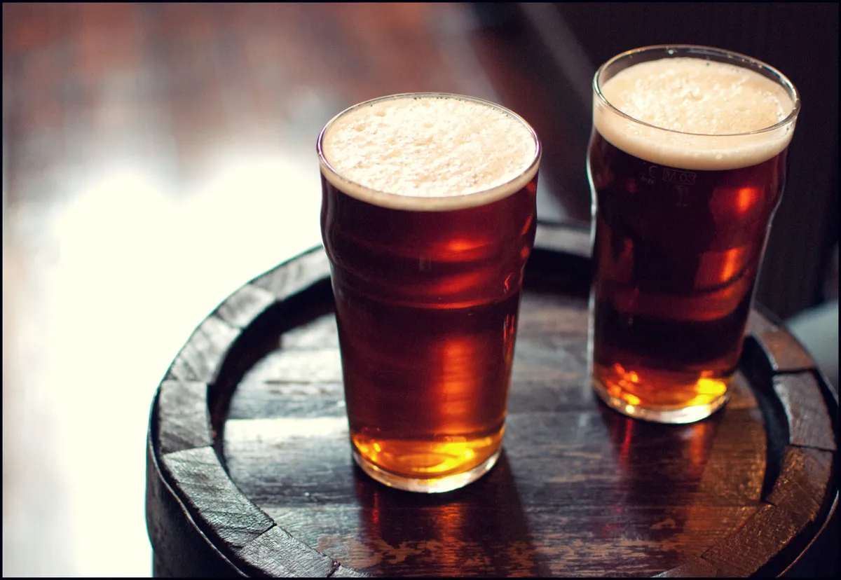 Deux pintes de bière amère sur un tonneau en bois dans un pub londonien