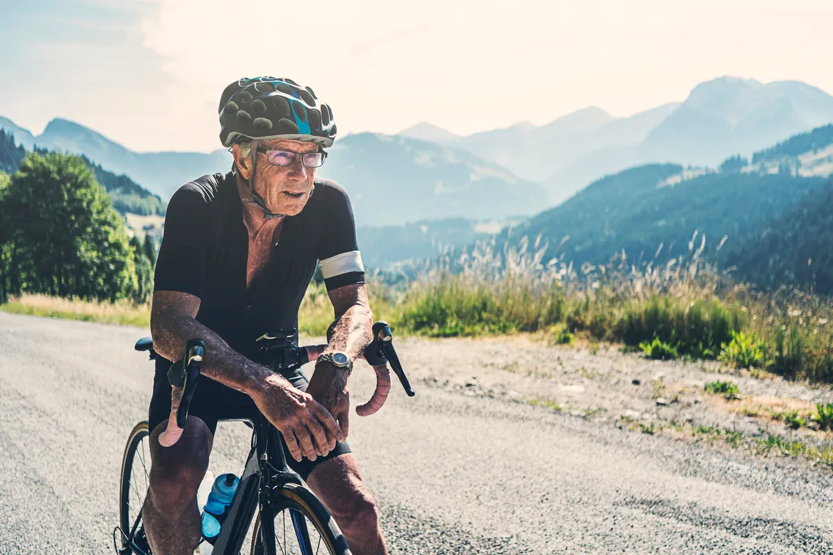 Homme senior reposant sur un guidon de vélo