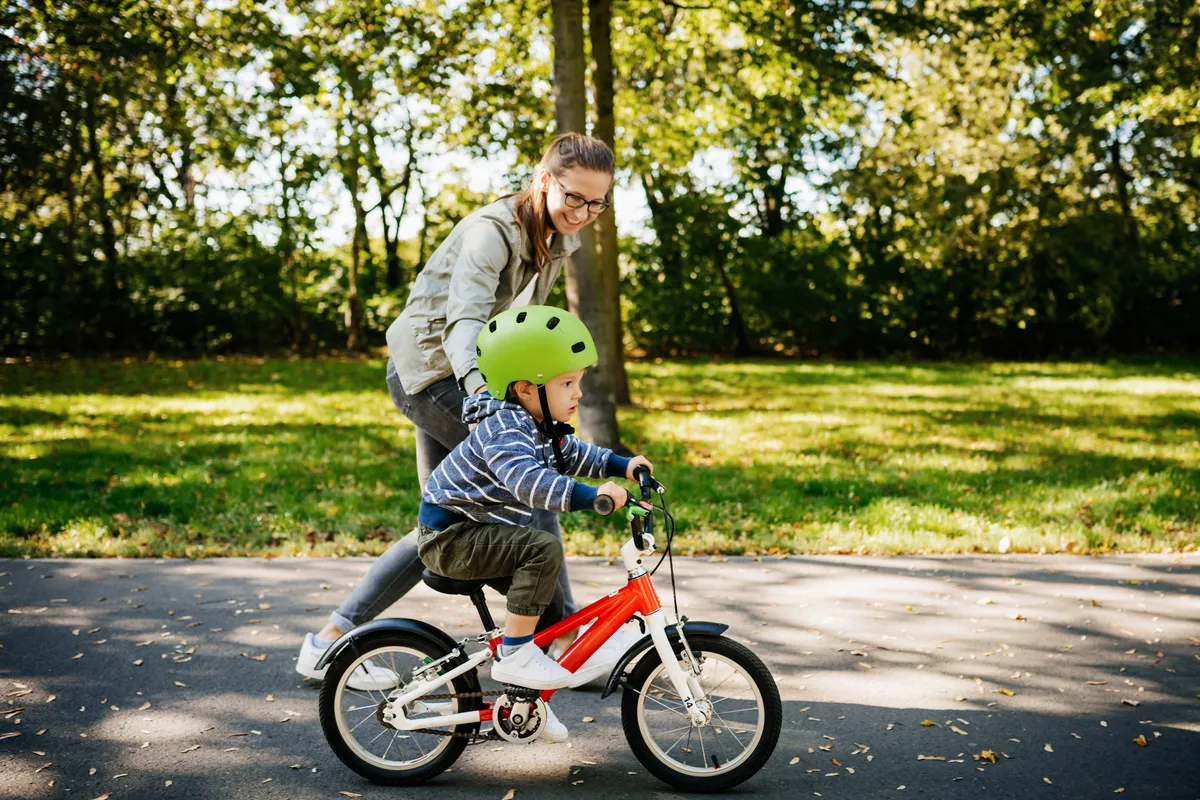 Enfant apprenant à faire du vélo lors d'un après-midi ensoleillé dans le parc.