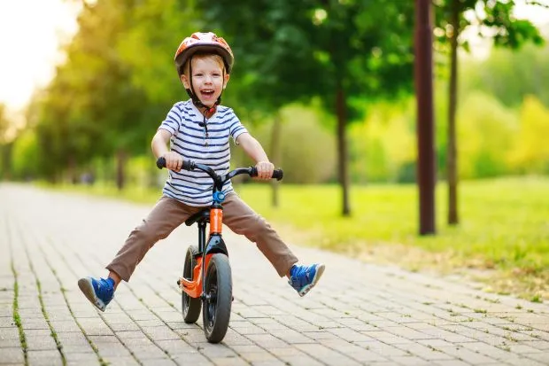 Jeune enfant équitation vélo d'équilibre dans le parc