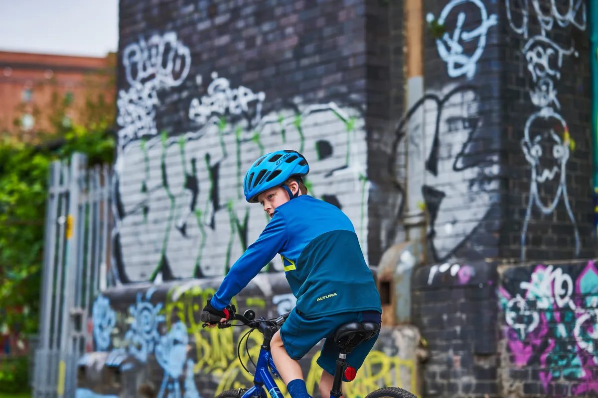 Garçon regardant par-dessus l'épaule gauche en faisant du vélo