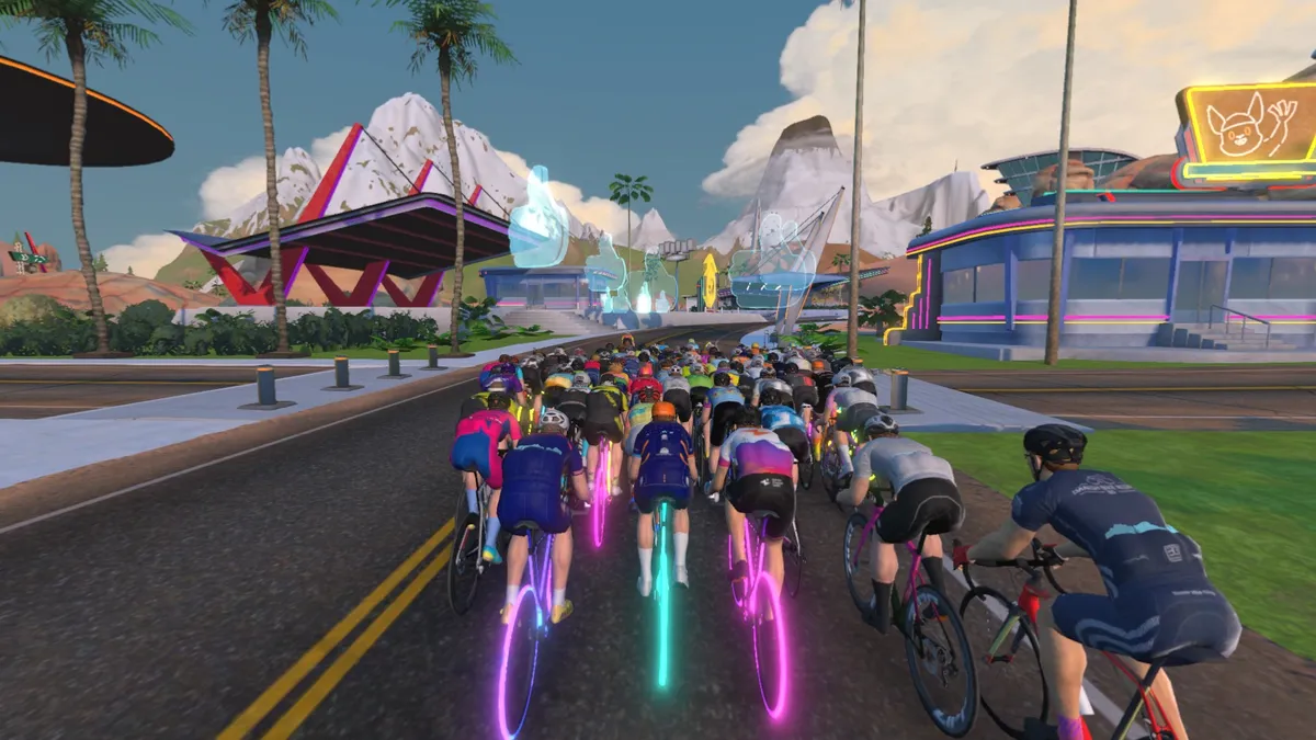 Graphique du jeu de Zwift montrant des coureurs virtuels faisant du vélo sur une route.