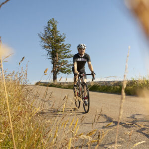 man riding road bike grass
