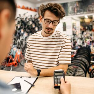Customer paying his bill at a bike shop