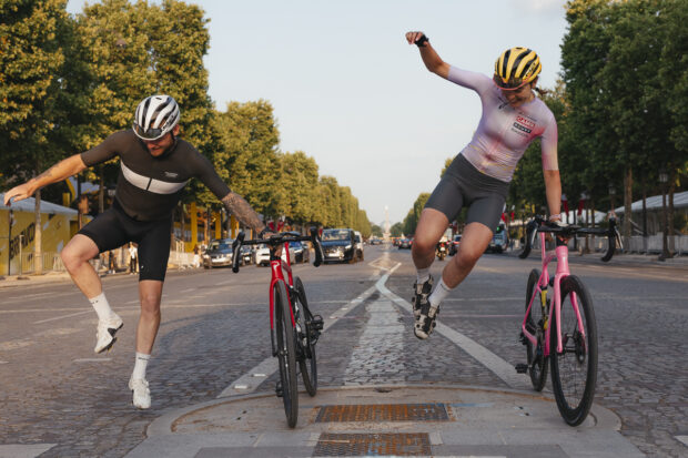 A man and woman jump next to their bikes in Paris