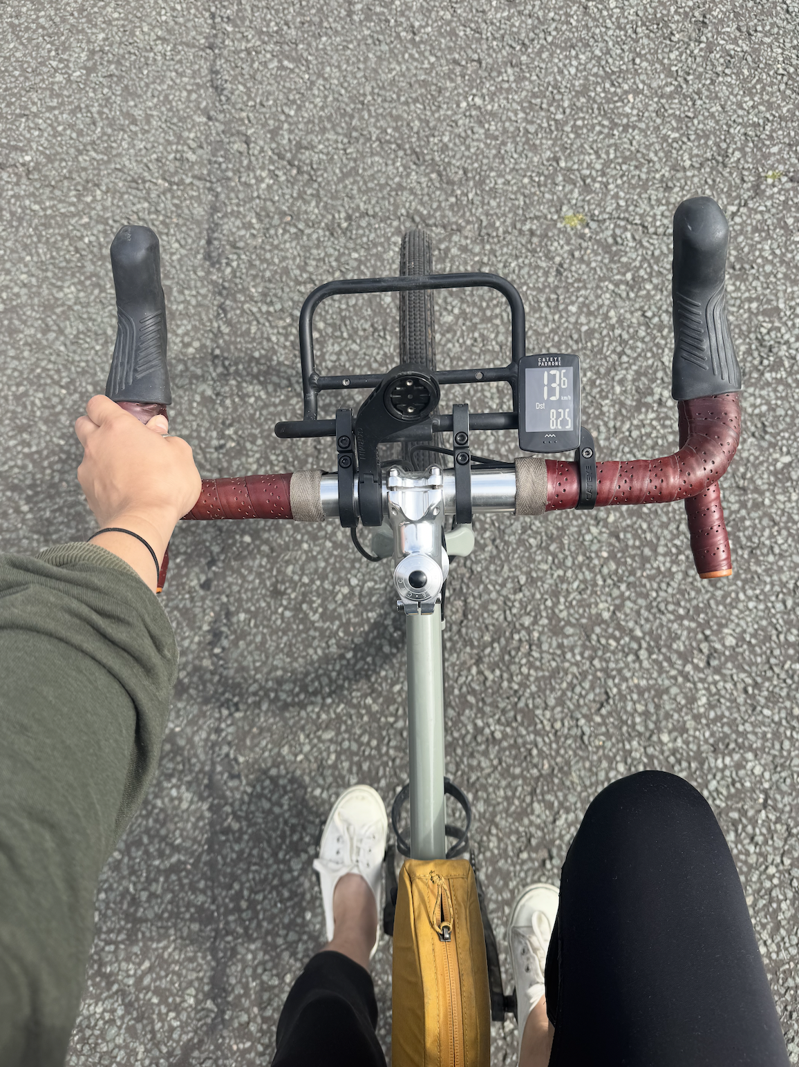 Le Padrone Cateye se trouve sur le guidon d'un vélo à côté d'une grille avant. Son affichage est allumé et affiche KM / H et la distance