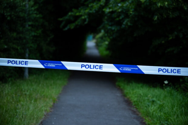 Police tape across a path