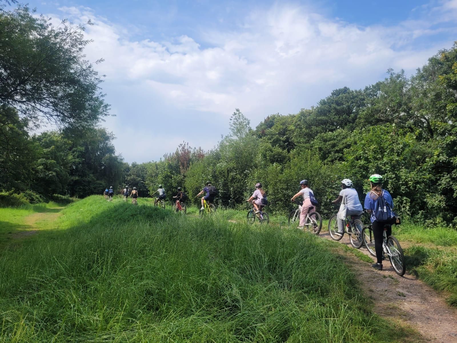 A group of girls cycle along a path