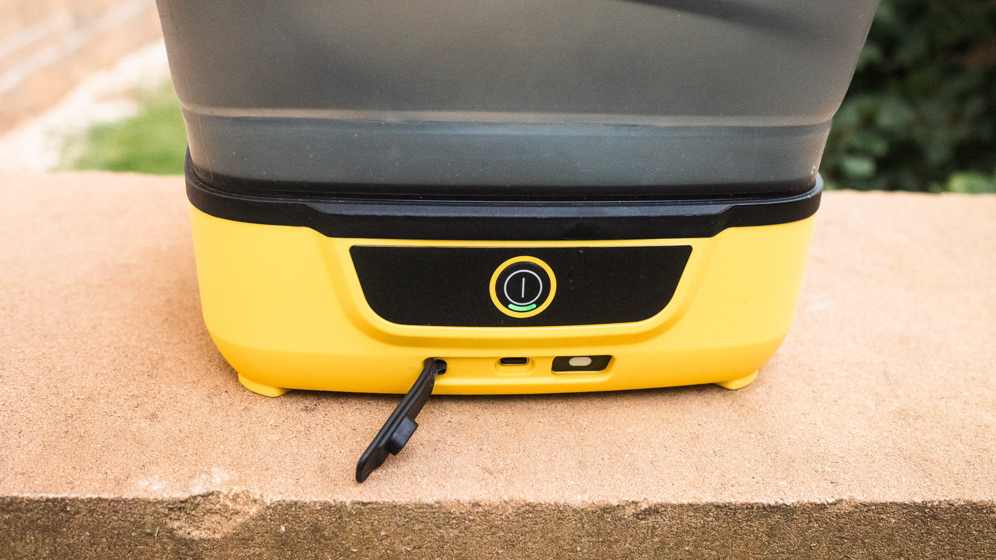 Détails du nettoyeur pliable Kärcher OC3 montrant le bouton d'alimentation et le port de chargement