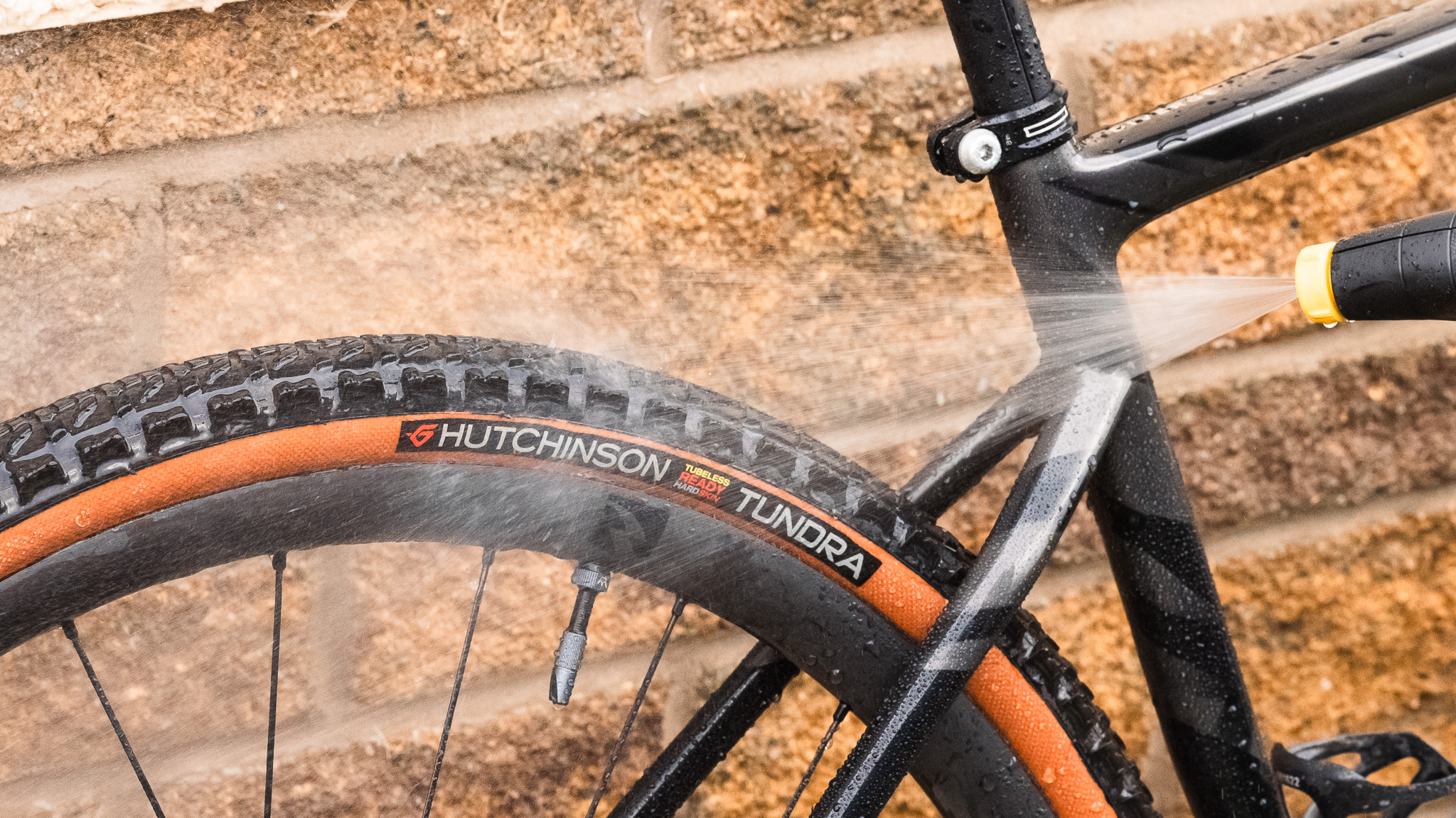 Gros plan du pistolet à pression Kärcher OC3 pulvérisant sur l'arrière d'un Specialized Diverge